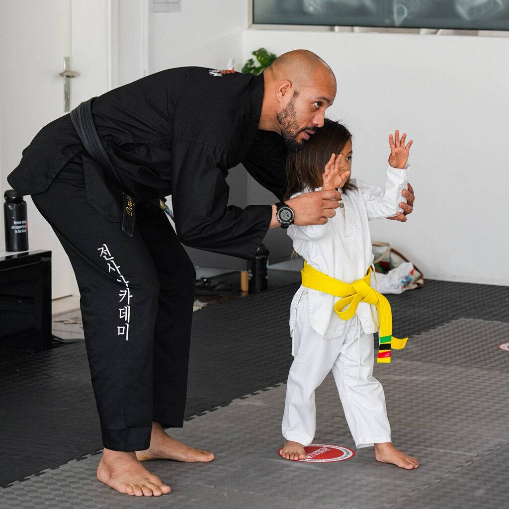 Warrior Academy trainer showing young student techniques