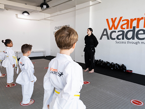 Children listening to instructor at Warrior Academy building discipline, respect, and self belief.