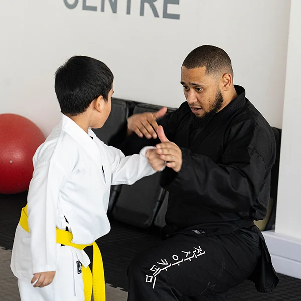 Trainer showing student techniques for martial arts at Warrior Academy