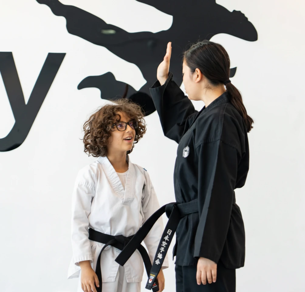 Child proud of a new belt at Warrior Academy, building confidence through martial arts in Dubai