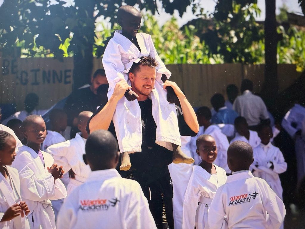 Sebastian Bates lifted up by students at a Bates Foundation academy in Kenya