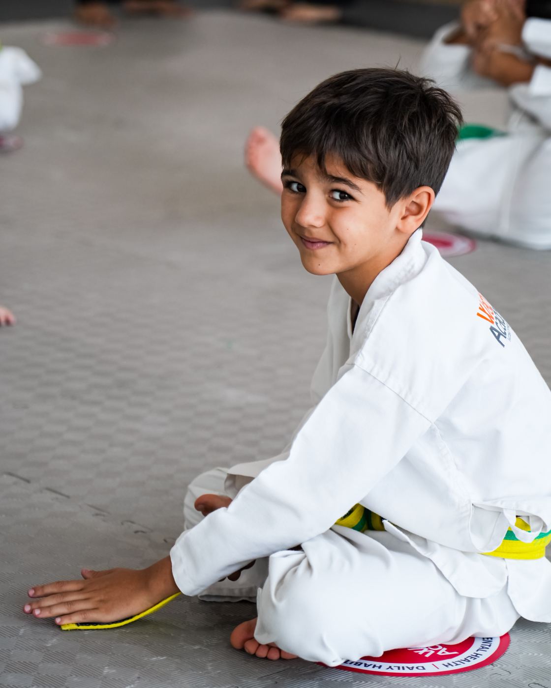 A boy smiles with confidence on the mat