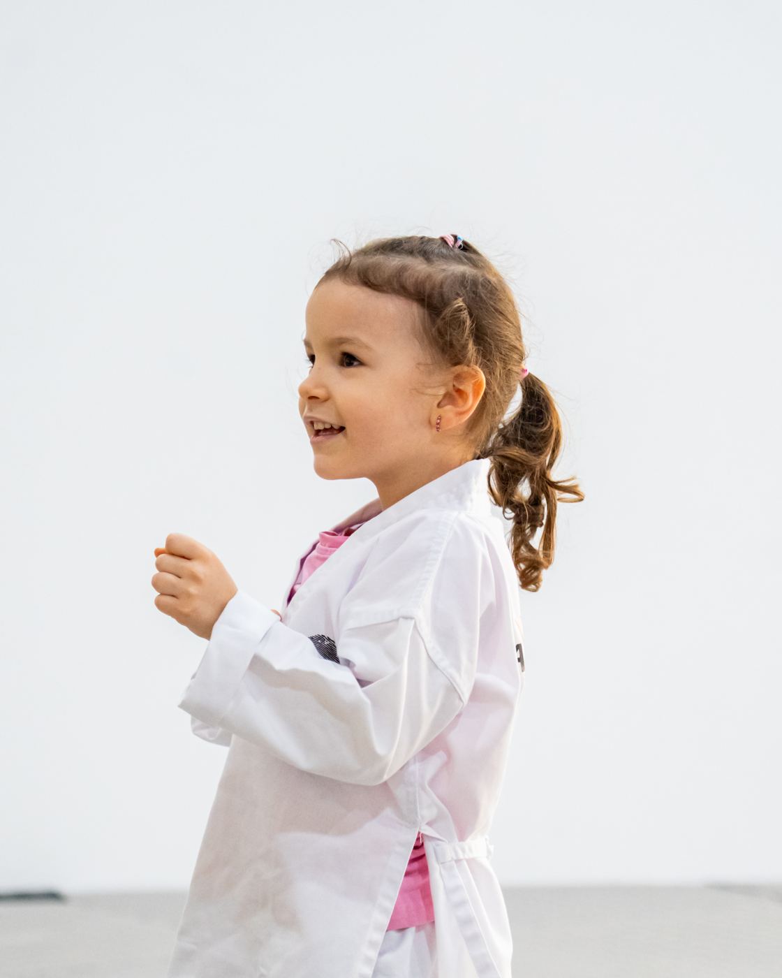 A little girl smiles in her Warrior Academy uniform